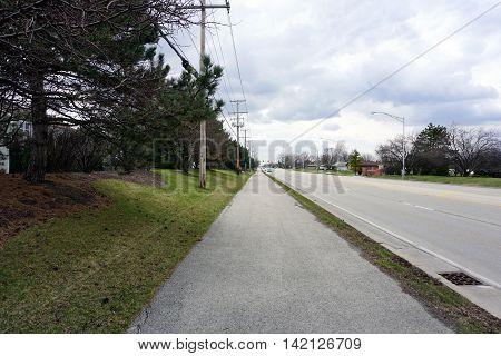 A wide sidewalk, along Caton Farm Road in Joliet, Illinois, accommodates both pedestrians and bicyclists.