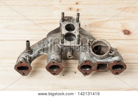 closeup intake manifolds on wooden desk, spare part