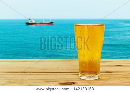 Beer glass on a blurred background of the sea.