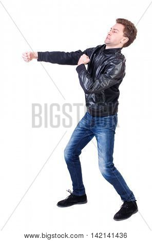 back view of guy funny fights waving his arms and legs. Isolated over white background. Rear view people collection.  backside view of person.Curly guy in a black leather jacket clumsily fighting. 