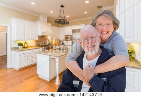Happy Loving Senior Couple Hugging Inside Custom Kitchen.