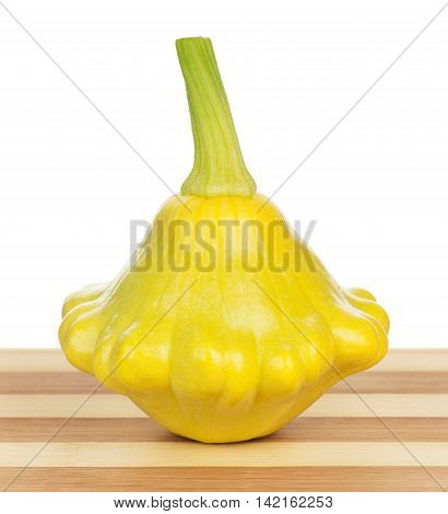 Yellow patty pan squash on the cutting board isolated over white background