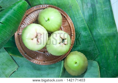 Green fresh rose apple on leaf banana