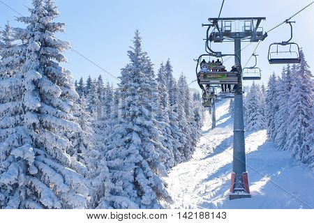 Kopaonik, Serbia - January 22, 2016: Ski resort Kopaonik, Serbia, people on the ski lift among the snowy white pine trees
