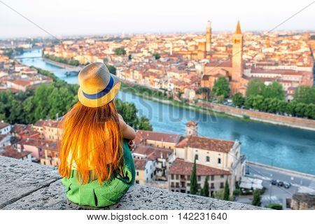 Woman enjoying beautiful view on Verona city in Italy on the sunrise. Verona is famous city of love in the north of Italy.
