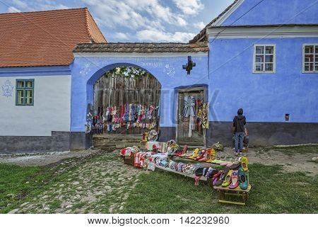 Viscri Romania - July 21 2016: Handmade wool and felt clothes designed by the locals exhibited in front of their houses on a narrow street of the Saxon landmark village in Transylvania.