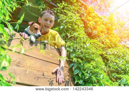 Smiling boy with dog on treehouse. Summer time!