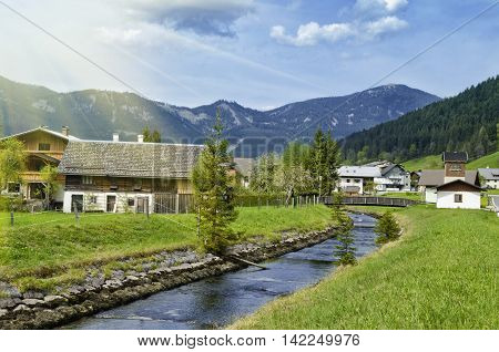 Beautiful view of Alpine Gosauschmied village green valley and river. Traditional austrian houses in Alps mountains. Salzkammergut Austria.