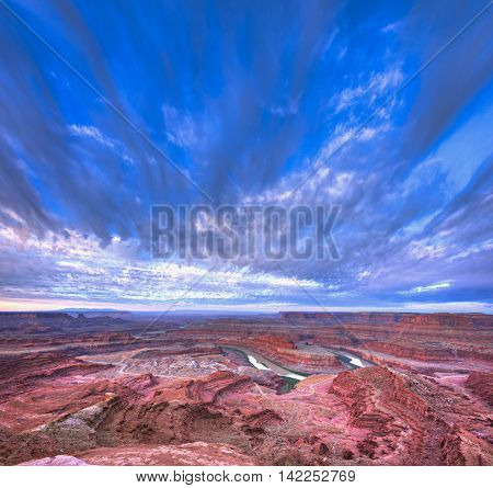 Sunrise illuminates clouds and the canyon walls of this colorful sunrise scene from Deadhorse Point. Deadhorse Point State Park is adjacent to Canyonlands National Park and near Moab Utah.