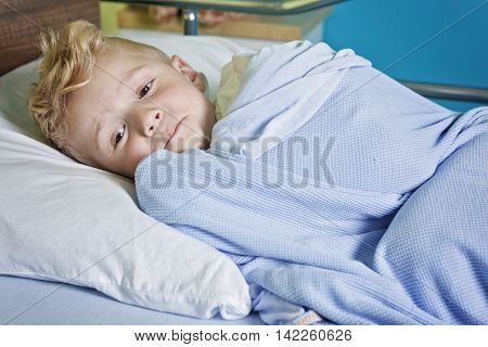 A sick little boy in a hospital bed