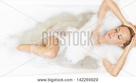 Wellness Concepts and Ideas. Sensual Caucasian Blond Woman Relaxing In Bathtub with Bubble Foam. Horizontal Shot