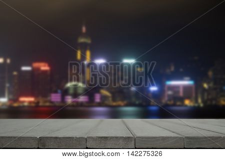 Night Building And Gray Wooden Desk Space.