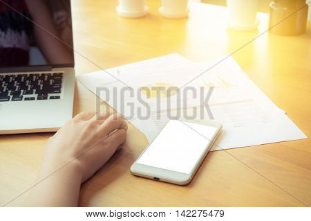close up hand business women using mouse and laptop on wooden desk in office with morning light.