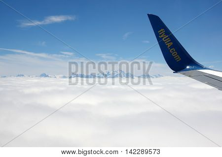 GENEVE AIRPORT SWITZERLAND ALPES - APRIL 28 2015: An Aircraft operated by UIA (Ukraine International Airlines) flying between Alpes mountains before landing in Geneve airport