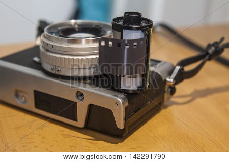 Antique SLR or Reflex camera with film roll over wooden surface
