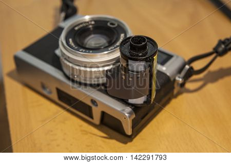 Antique SLR or Reflex camera with film roll over wooden surface