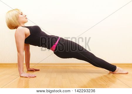 Blonde woman with short hair practicing yoga asana purvottanasana exercise sport