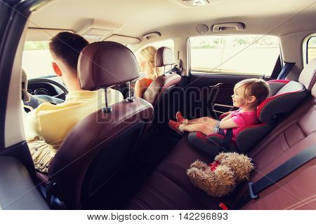 family, transport, safety, road trip and people concept - happy parents with little child driving in car