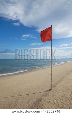 Warning Sign Of A Red Flag At A Beautiful Clean Beach With A Blue Sky, Cloud And The Sea, High Contr
