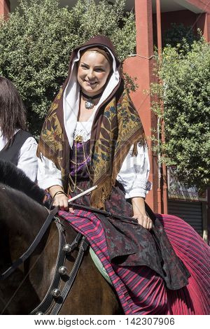 SELARGIUS, ITALY - September 14, 2014: Former marriage Selargino - Sardinia - portrait of a beautiful woman with a traditional Sardinian costumes parading with his horse - Sardinia