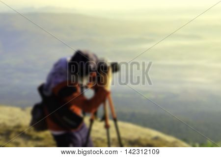 blurred image of hipster handsome man photography standing shooting camera with nature enjoy and happy at mountain.