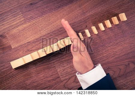Risk management and insurance concept. Risk manager (or another business person) has problem solution. Businessman stop domino effect top view.