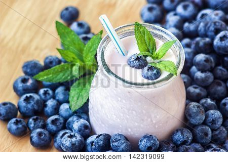 Beautiful appetizer blueberry fruit smoothie milk shake glass jar with juicy fresh berries background top view Yogurt cocktail Natural detox Liquid ice cream hurtleberry huckleberry winberry fraughan