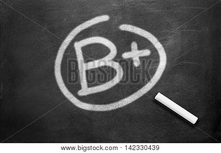 Chalk and grade b plus write on chalkboard background
