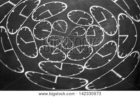 Clock from chalk on black chalkboard background texture