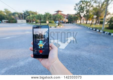 California, United States - July 30, 2016: Close up view of a person hand holding a smartphone and playing Pokémon Go