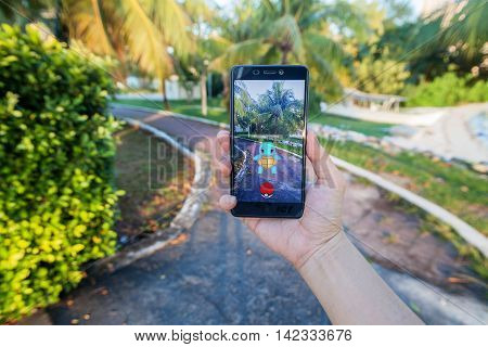 California, United States - July 30, 2016: Close up view of a person hand holding a smartphone and playing Pokémon Go