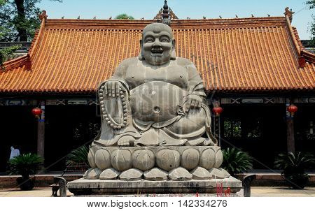 Shi Fang China - June 23 2007: Giant stone Buddha with rotund belly in a courtyard of the historic Luo Han Temple