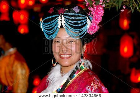 Lijiang China - April 19 2006: Woman wearing traditional Naxi clothing and a unique beaded headdress on Xing Hua Street