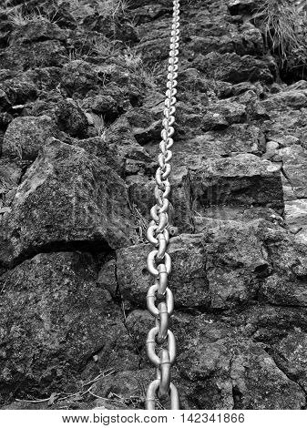 Detail Of Chain Anchored In Hard Whinstone Rock. Climbers Path