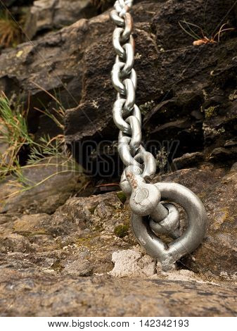 Steel Bolt Anchor Eye In Hard Basalt Rock. End Of Steel Chain