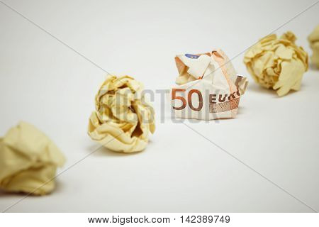 Crumpled euro bill among office paper. Business concept.