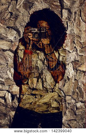 Closeup of one handsome passionate expressive cool young brunette photographer men with long curly hair holding a vintage SLR camera standing against red background - Abstract Texture