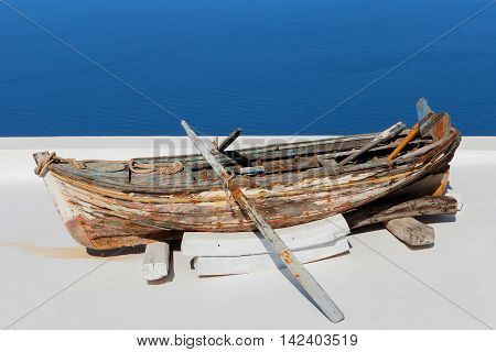 Old wooden rowing boat overlooking Santorini's bay