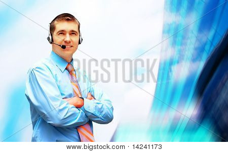 Homme d'affaires de bonheur en headphoness sur le fond d'architecture d'entreprise