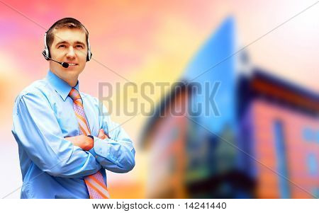 Homme d'affaires de bonheur en headphoness sur le fond d'architecture d'entreprise
