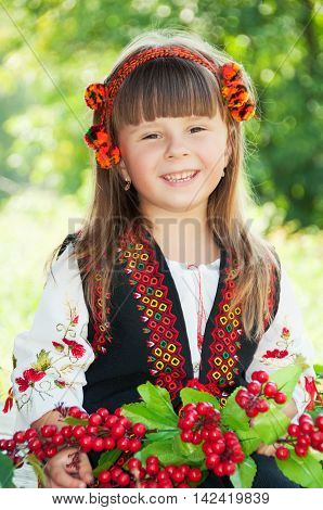 Portrait of a smiling little girl in a wreath in the national Ukrainian Hutsul costume