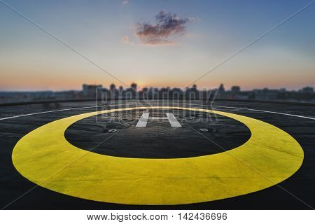 Helipad on the roof of a skyscraper after raining with cityscape view and sunset