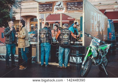 Saint-Petersburg Russia - August 11-14 2016: Bikers from all over Europe on Nevsky prospect during annual European Bike festival Harley Davidson Days best motorcycle events. Tourist mans eating drinks in street food restaurant Frank meat. Lifestyle concep
