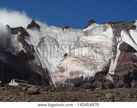 Mountain house on a background of the ice wall