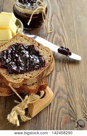 Wholegrain toast with blackcurrant jam and butter, vertical