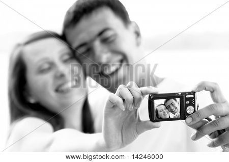 Un couple attrayant ensemble sur le fond blanc, prenant un autoportrait.