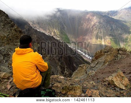 Man watching multicolored mountains and glacier. Beautiful Caucasus.