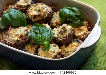 small stuffed champignons baked in a casserole dish with basil garnish selected focus narrow depth of field