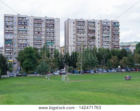 People at a soccer field in front of an industrialized apartment block in Jelenia Gora, Poland