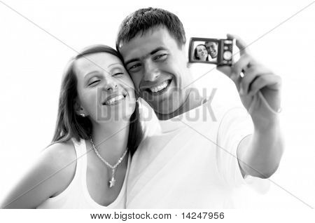 Un couple attrayant ensemble sur le fond blanc, prenant un autoportrait.